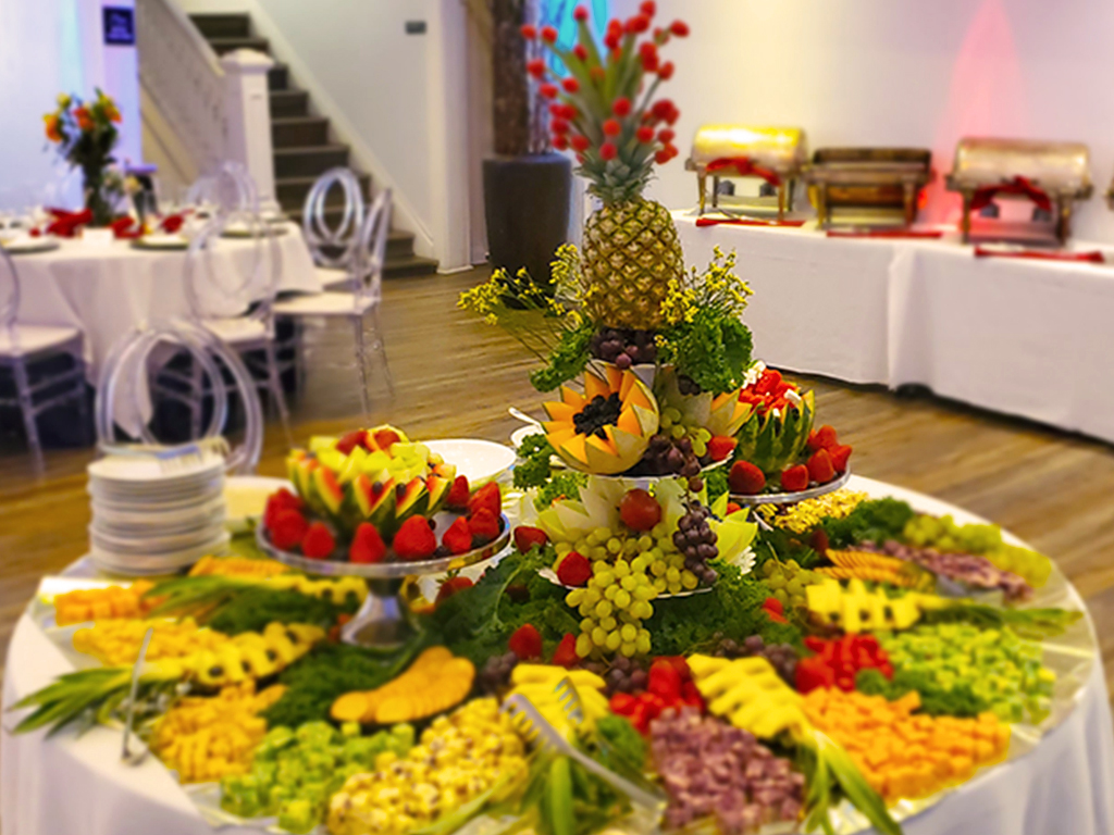A beautifully arranged wedding reception table with gourmet dishes and floral centerpieces.